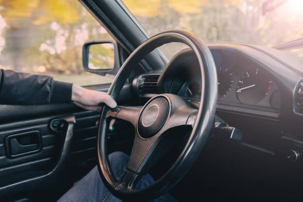 istock car driver holds the wheel on a sunny day. 1133000509