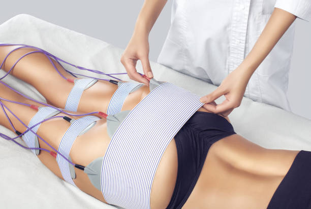 the procedure of myostimulation on the legs and buttocks of a woman in a beauty salon. - electrode imagens e fotografias de stock