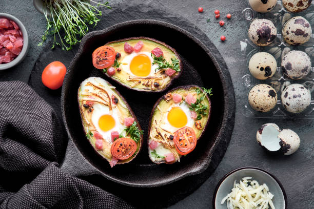 istock Keto diet dish: Avocado boats with ham cubes, quail eggs, cheese, ingredients around 1133004008