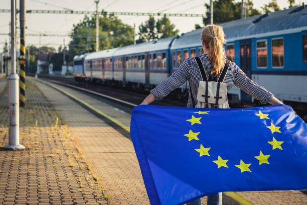 istock Backpacker woman with EU flag standing on railroad station. 1133005161