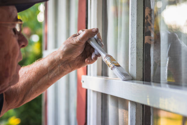 istock Active senior repairman is painting window frame by paintbrush. 1133007095