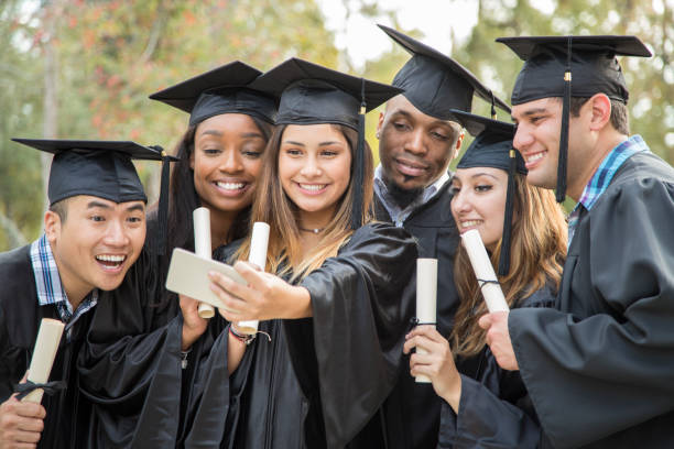 College student friends take selfie after graduation ceremony.