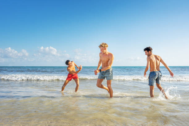 istock Group of young men playing at the beach 1133007759