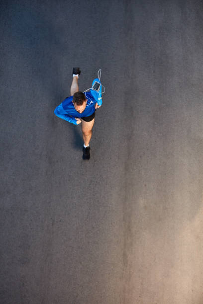 widok z góry na człowieka biegnącego na ulicy. - muscular build sprinting jogging athlete zdjęcia i obrazy z banku zdjęć