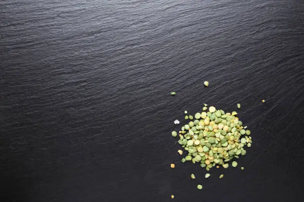 Photo of Dried half green peas on the kitchen board. View from above.