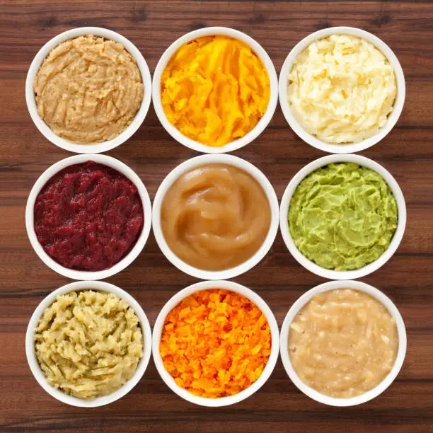 Nine bowls with varieties of mashed foods