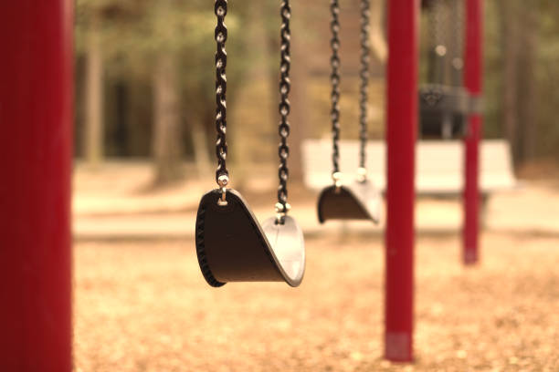 качели установлены на пустой школьной или парковой игровой площадке. - swing playground empty abandoned стоковые фото и изображения
