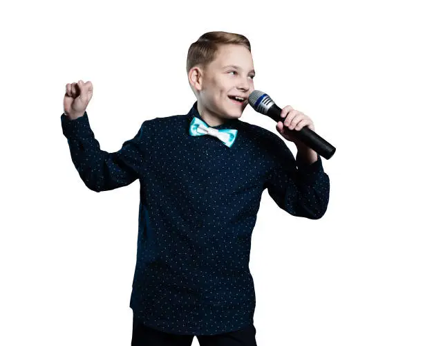 Photo of boy singing in microphone. child in karaoke. isolated