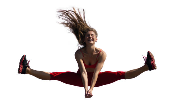 Young caucasian girl performs twine jumping on isolated backround.