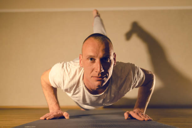 istock Young man in white shirt stretching training at yoga class in studio 1133017245