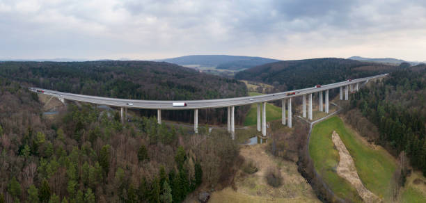 Panoramic aerial view of highway bridge through forestland
