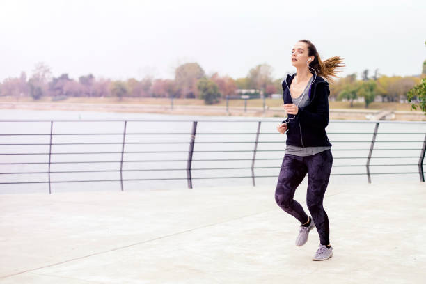 istock View at active young beautiful woman running by river 1133021519
