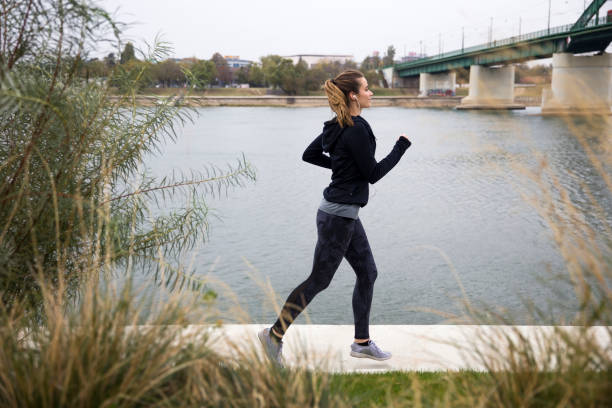 istock Female runner near river side 1133021546