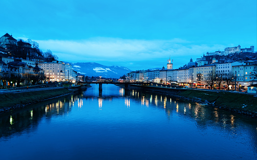 Panoramic view with Landscape of Old town and Hohensalzburg castle in Salzburg in Austria in Europe. Mozart city in Austrian Alps at Salzach River in winter. Fortress and Cathedral. In evening