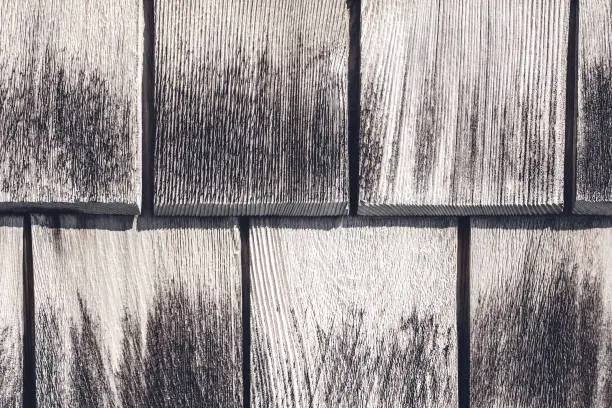 Texture of weathered wooden tiles. Detail of a country house wall.