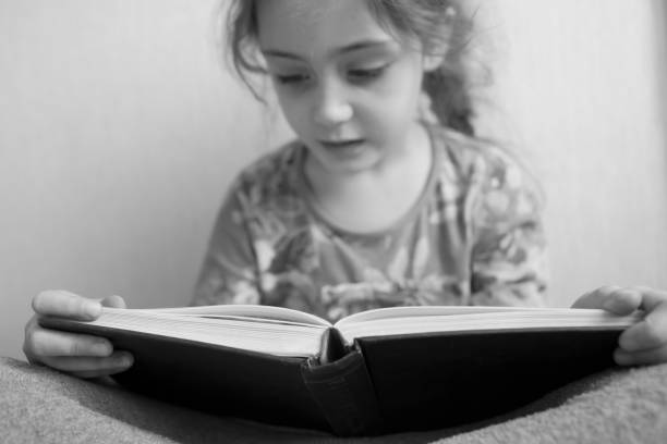 istock Little girl reading a book 1133028939