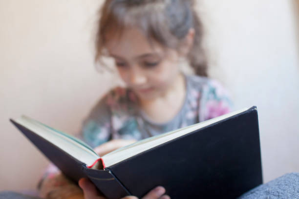 istock Little girl reading a book 1133028962