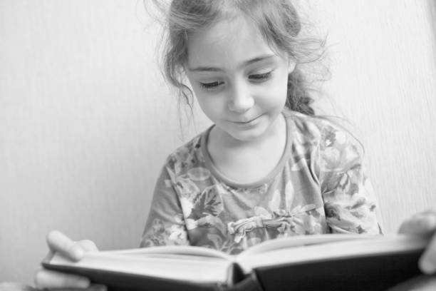 istock Little girl reading a book 1133028963