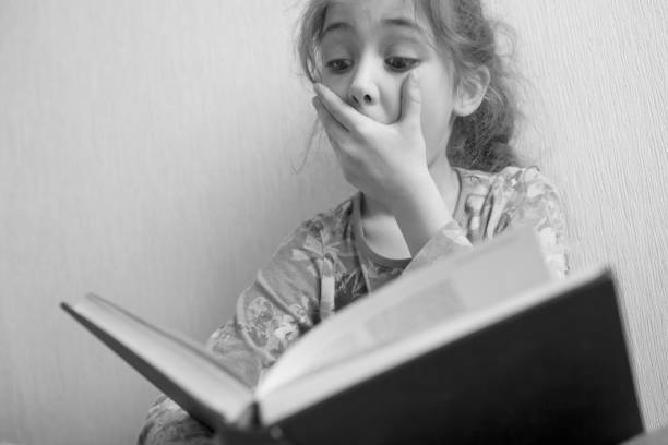 istock Little girl reading a book 1133028967