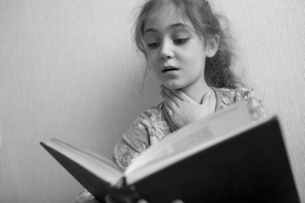 istock Little girl reading a book 1133028974