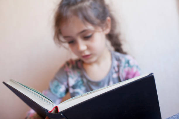 istock Little girl reading a book 1133028976