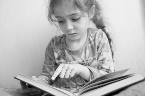istock Little girl reading a book 1133028982