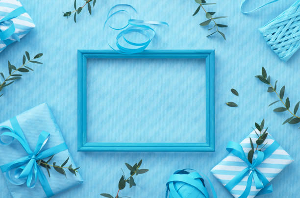 Flat lay in light blue hues with wrapped gift boxes decorated with eucalyptus twigs