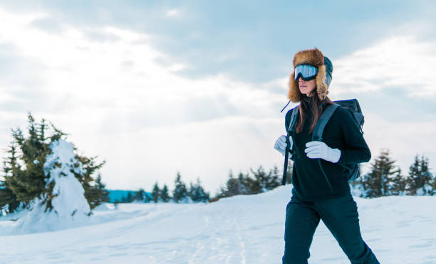 istock Woman skier with backpack walking through snowy forest 1133032043