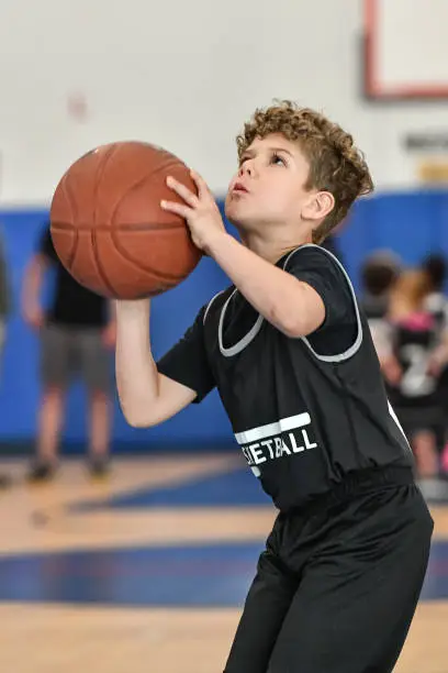 Basketball game with a cute little boy playing and having fun.