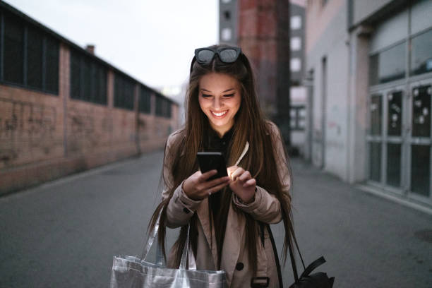 istock Businesswoman using smartphone on streets by night 1133035390
