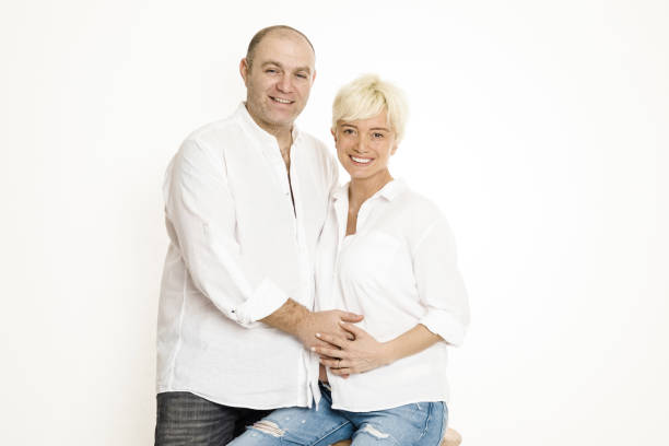 istock Pregnant woman with her husband over white background 1133035694