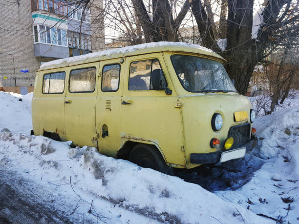 altes nicht arbeitstartiges auto im schnee unter einem baum - winter non urban scene snow tree stock-fotos und bilder