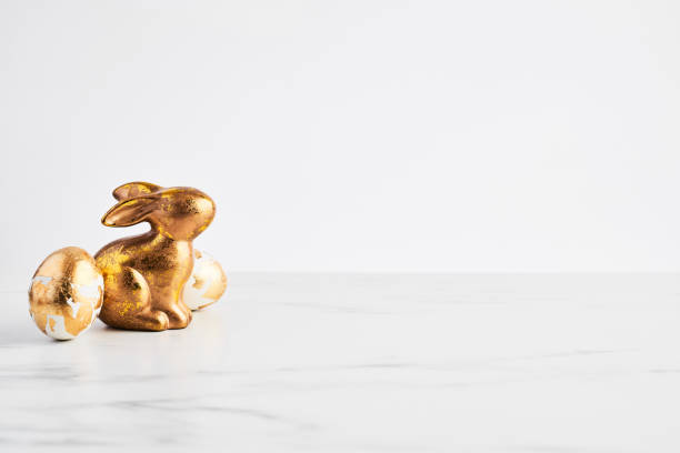 Easter greeting card, golden rabbit and eggs decorated with golden foil