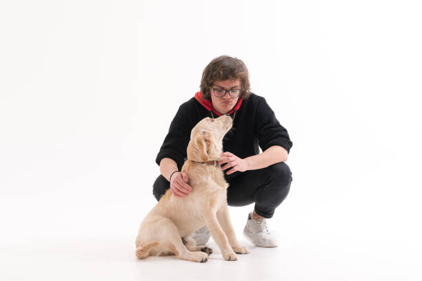 istock Young man with his golden retriever puppy dog 1133038457