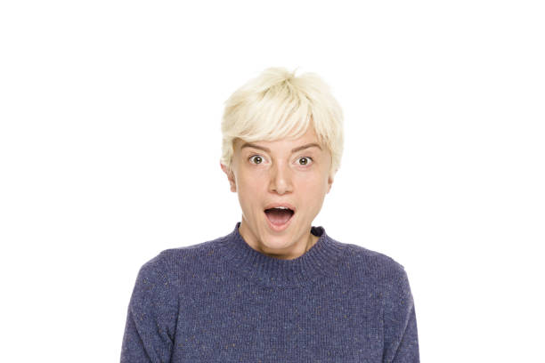 European woman with blond hair looks in surprise on a white background with copy space.