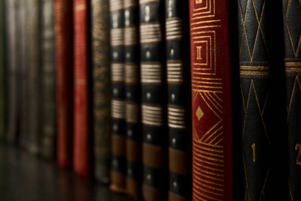 Old books on a bookshelf as abstract background. Vintage books on a wooden shelf, close-up. The colorful books in the library as education and knowledge concept