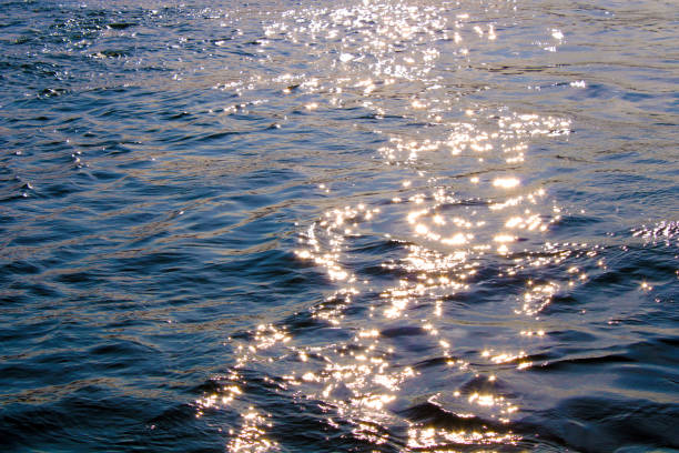 riflessi del sole sul mare all'ora del tramonto, mare lucido - sunrise sun gold sea foto e immagini stock