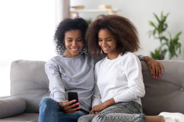 istock Different ages females sitting on couch at home using smartphone 1133045013