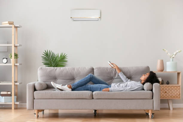 istock African female lying on couch use airconditioner breathing fresh air 1133045036