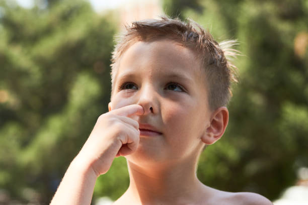 istock ute little boy enjoying picking his nose, close-up. 1133047699