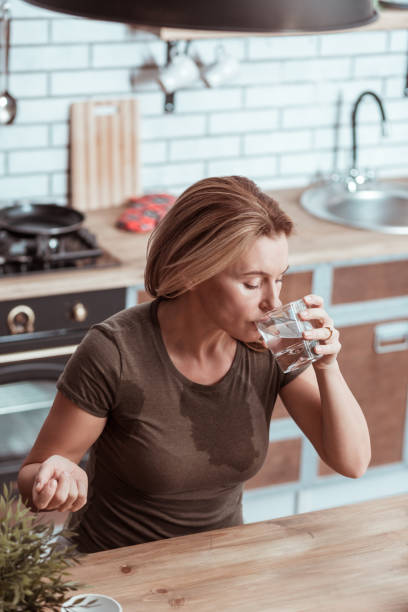 istock Sick woman feeling bad drinking water after taking pill 1133047939