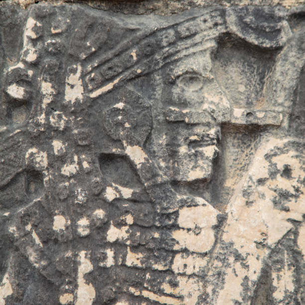 деталь барельефа резные фигуры в камне у основания стен большого бала суда на основании руин майя чичен-ица - the great court стоковые фото и изобр�ажения