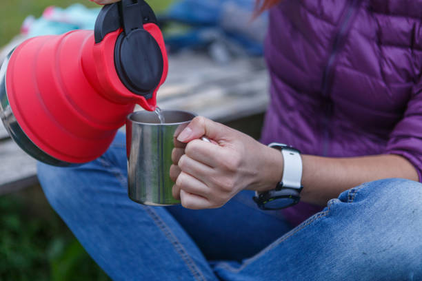 istock Woman pours tea from a kettle into the cup. Closeup concept 1133049121