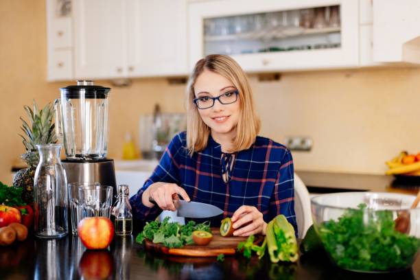 istock Woman cutting kiwi fruit in kitchen. 1133053277