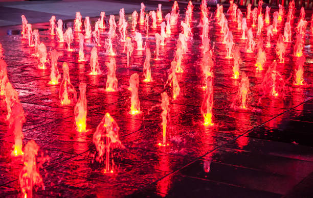 istock night red water fountain light illumination display in summer landscape background. Abstract, outdoor decoration, building exterior design, festival, event, reflection and beautiful scene concept 1133055827