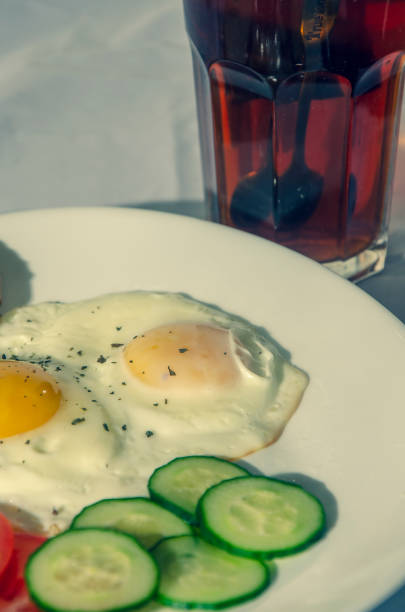 fried chicken eggs with fresh vegetables and bread. Traditional breakfast