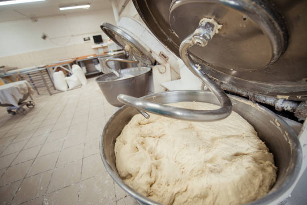 faire de la pâte pour le pain dans un malaxeur dans une boulangerie - bread making photos et images de collection