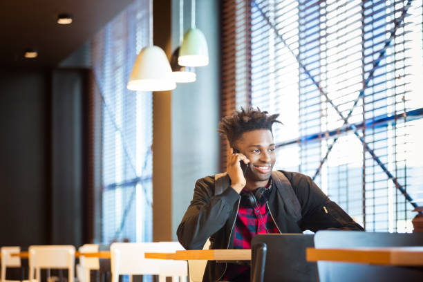 istock Smiling man talking on smart phone at airport cafe 1133070248