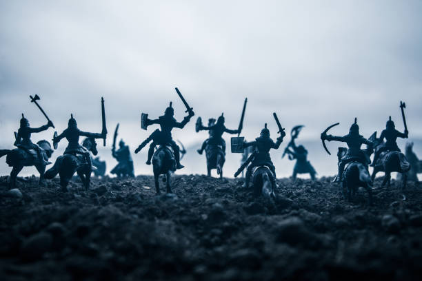 istock Medieval battle scene with cavalry and infantry. Silhouettes of figures as separate objects, fight between warriors on sunset foggy background. Selective focus 1133071696