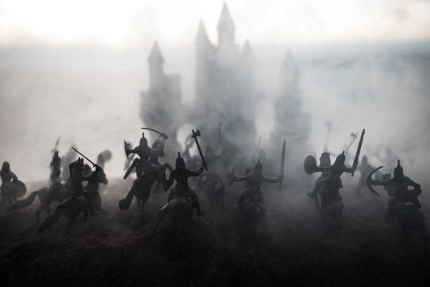 istock Medieval battle scene with cavalry and infantry. Silhouettes of figures as separate objects, fight between warriors on sunset foggy background. 1133071703